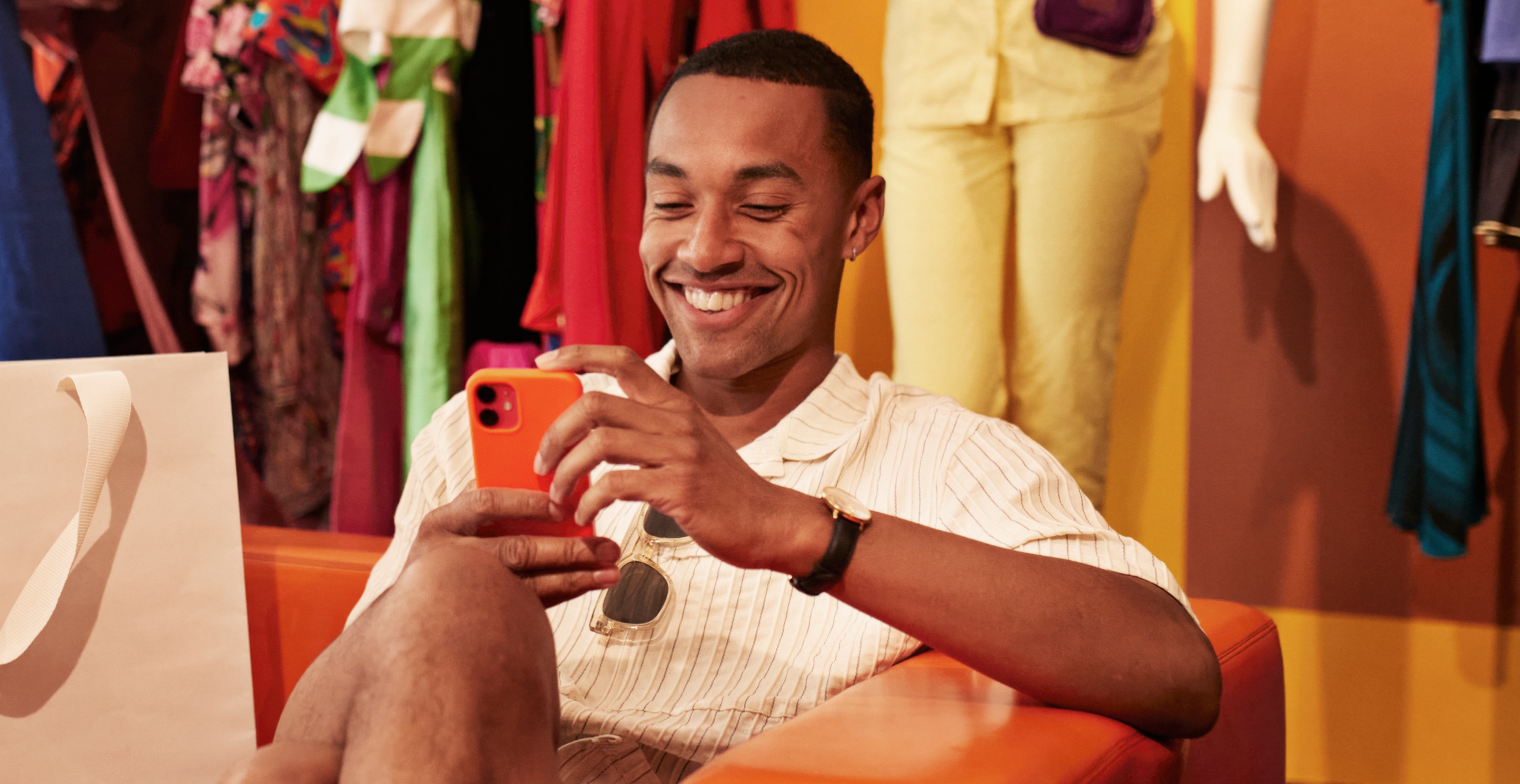 Man smiling while using a smartphone to shop
