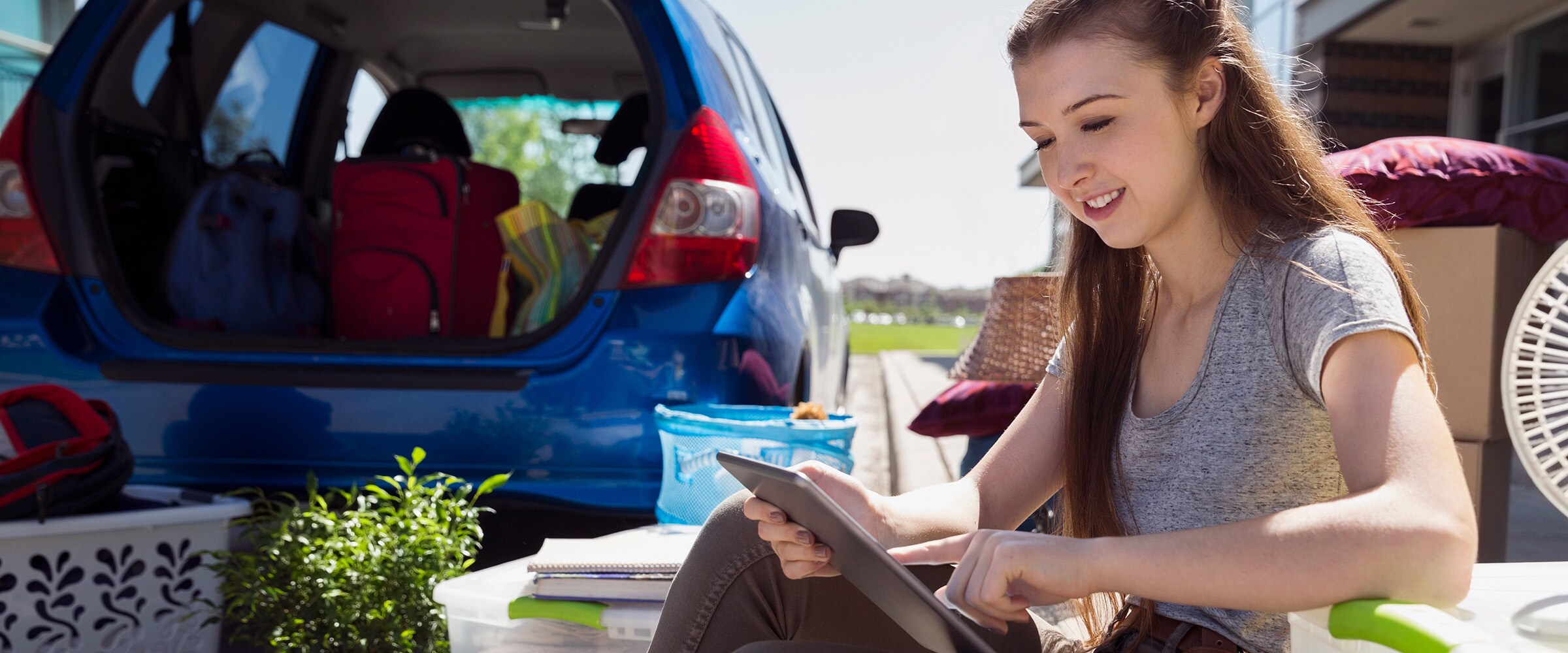Photo of college student unpacking car outside college dorm.
