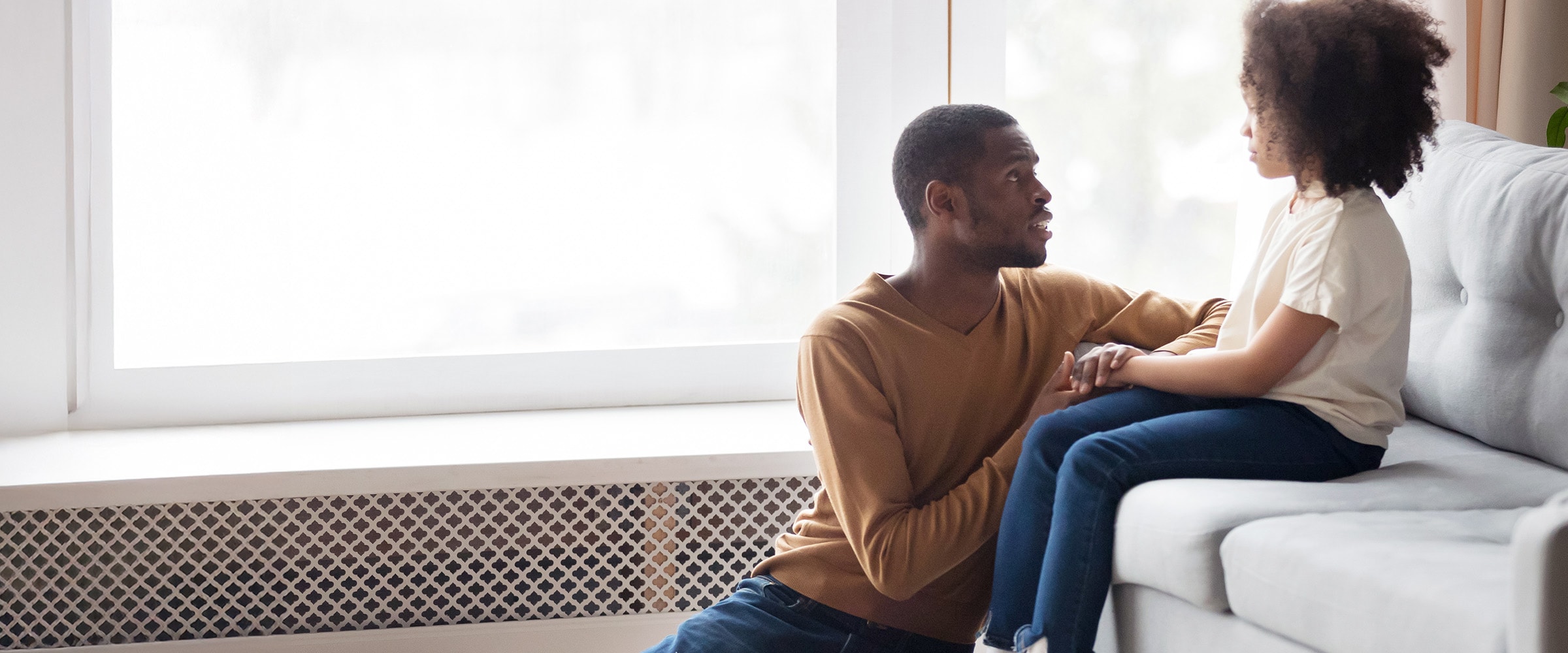 Photo of African-american dad talking to his daughter.