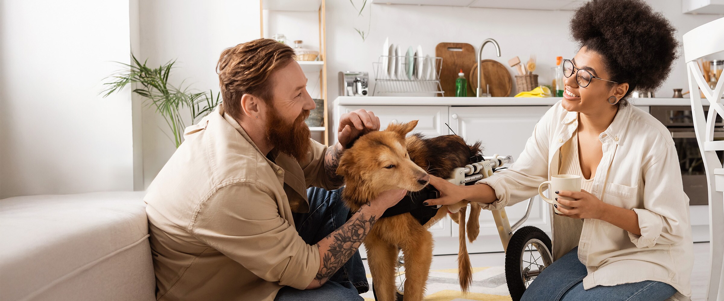 Photo of couple on living room floor petting dog.