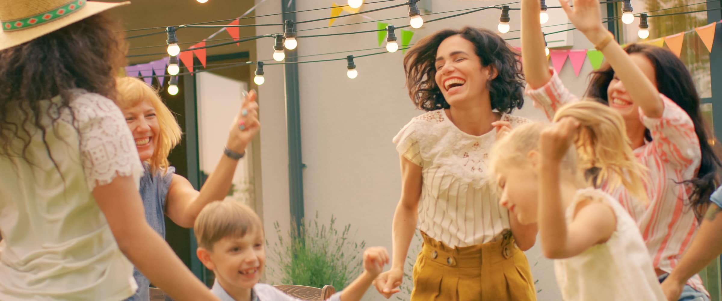 Photo of family dancing in a festive way outside a vacation spot.