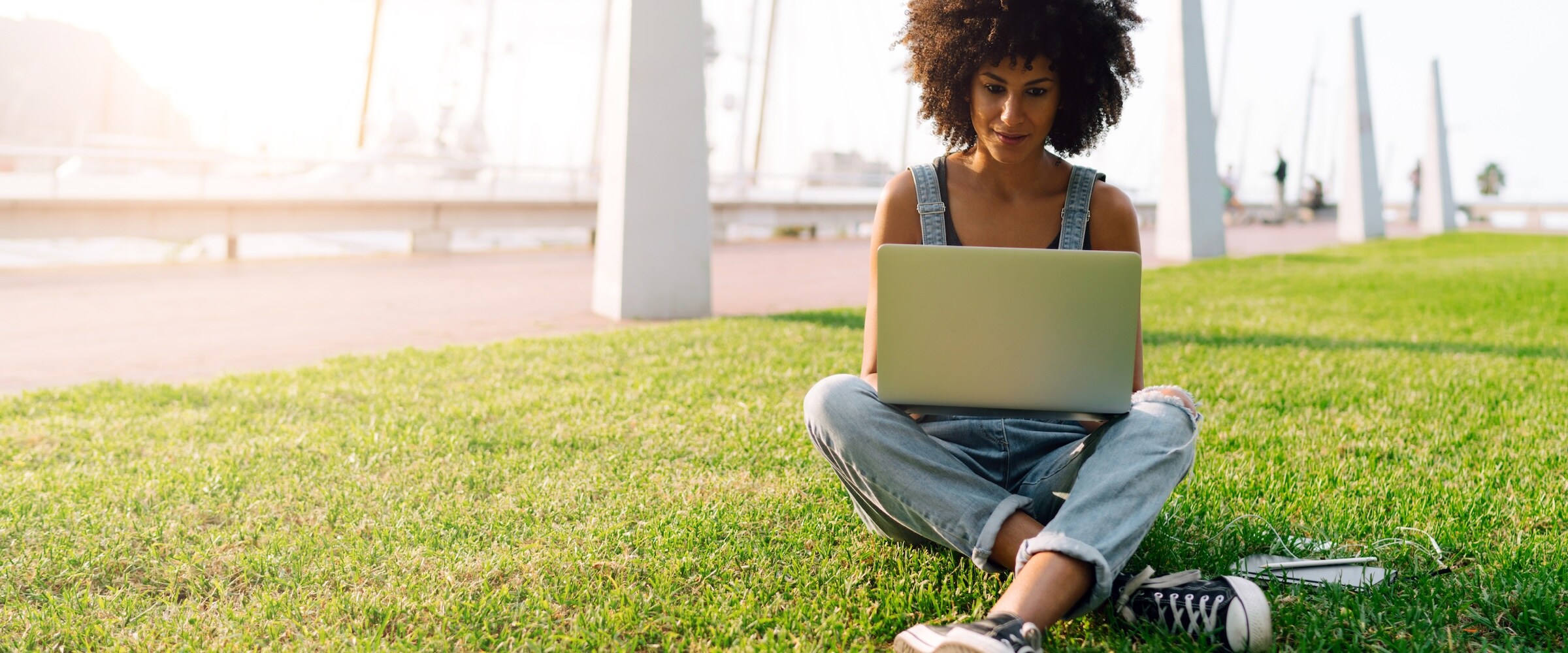 Photo of woman sitting on the lawn using a laptop.