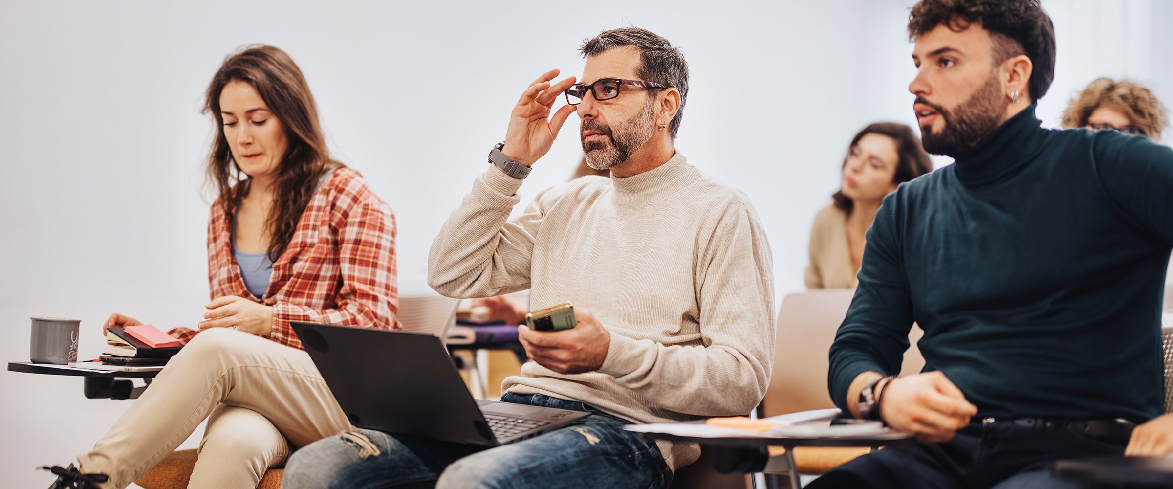 Photo of older man in a college course taking notes.
