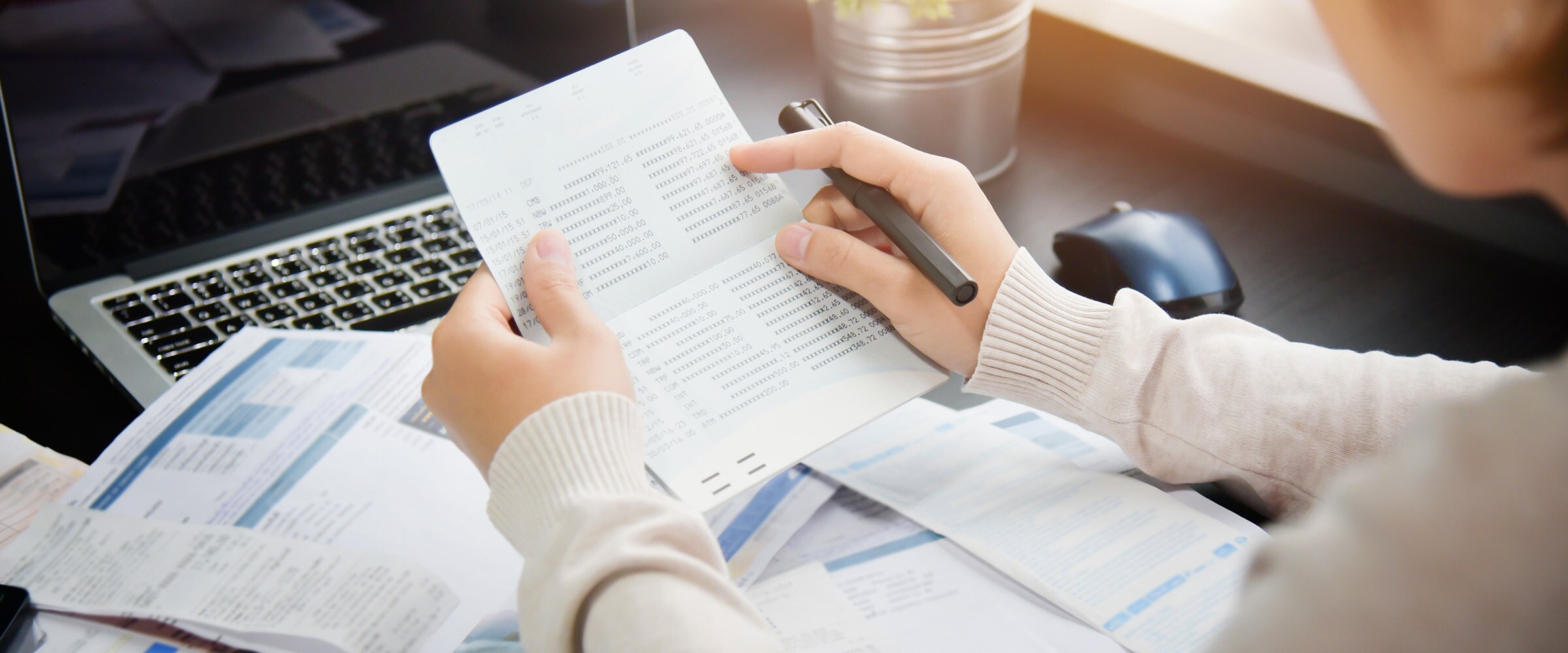 Photo of two hands holding income statements.