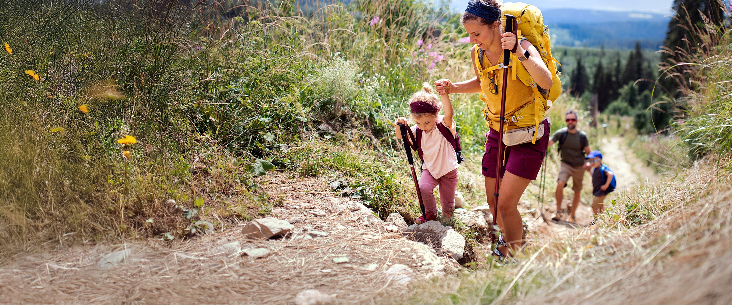 Photo of young family walking up a steep hill path.