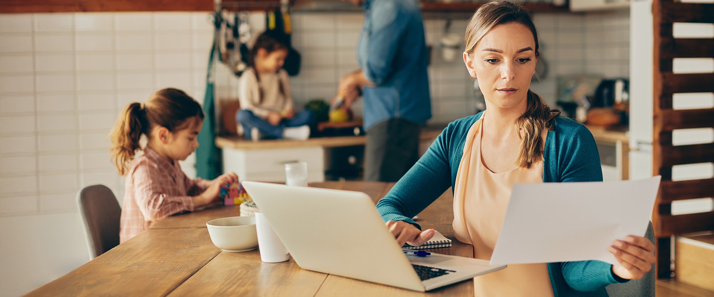 Photo of mom looking at her finances over the kitchen table.