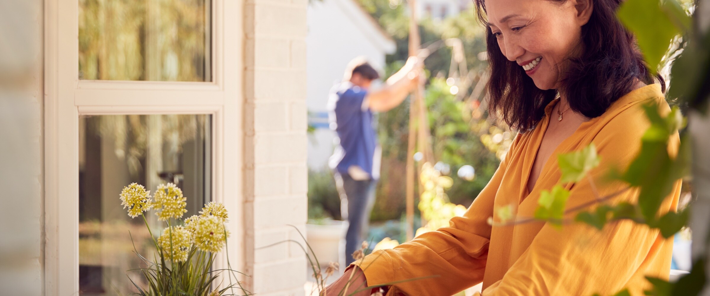 Photo of Asian woman tending to flowers.