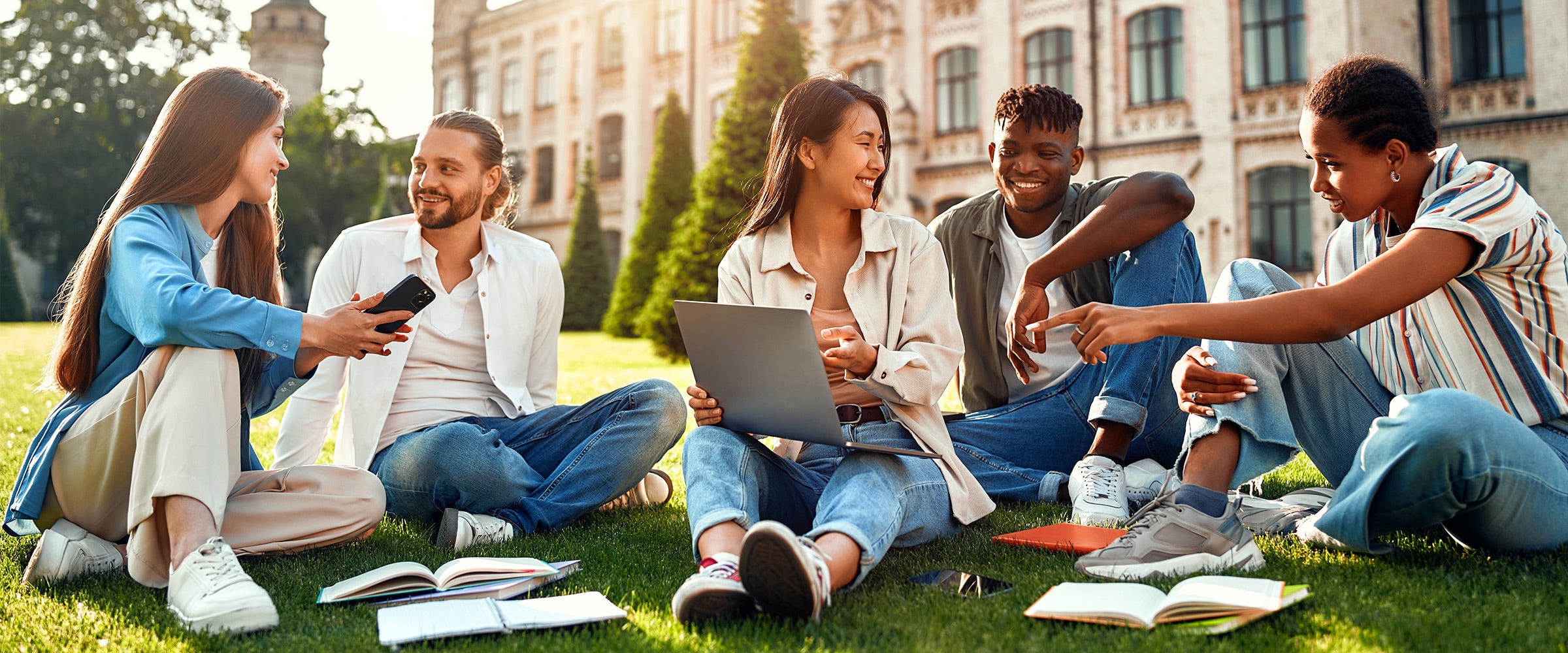 Photo of diverse mix on college students sitting on the campus quad.