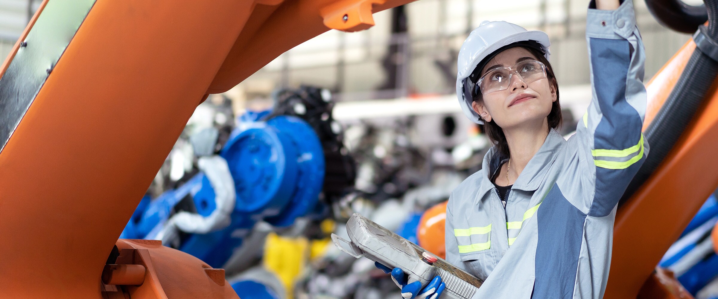 Photo of woman in hard hat working in a plant.