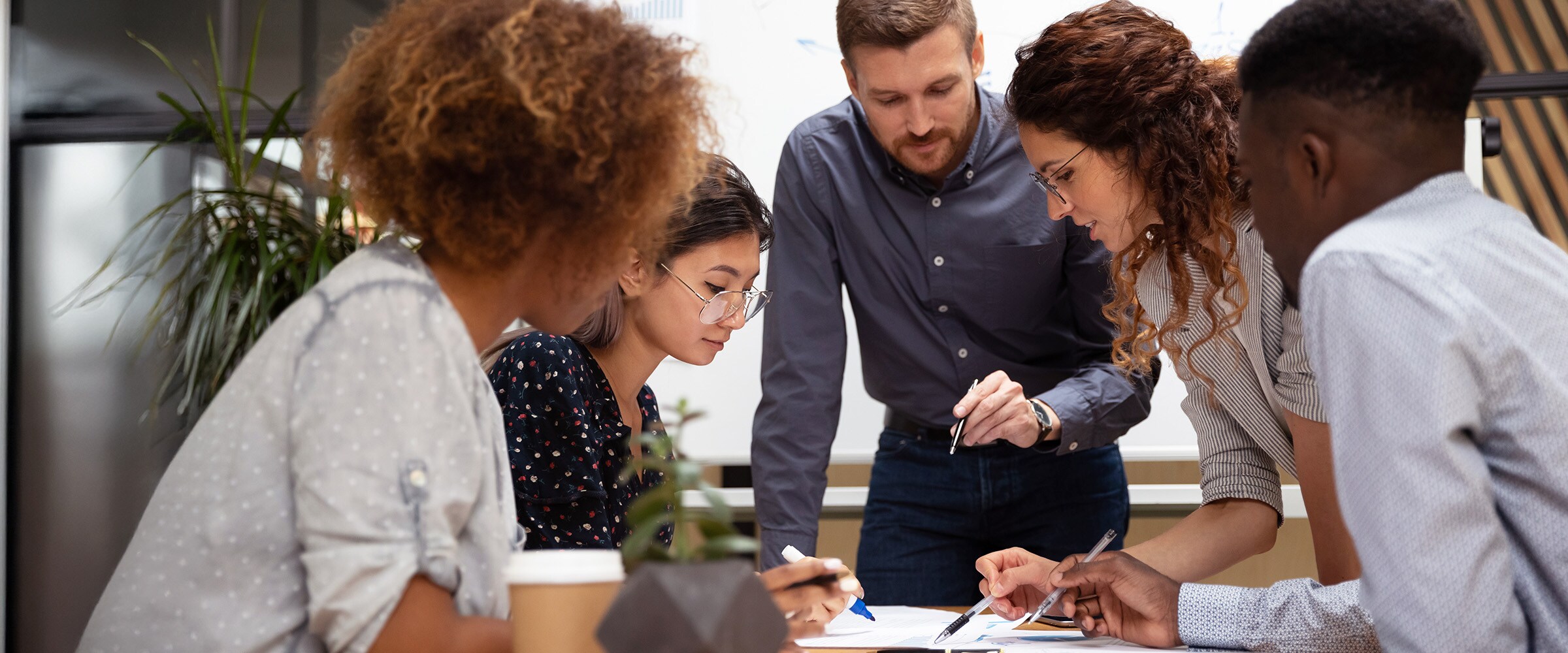 Photo of a work team talking around a table at the office.