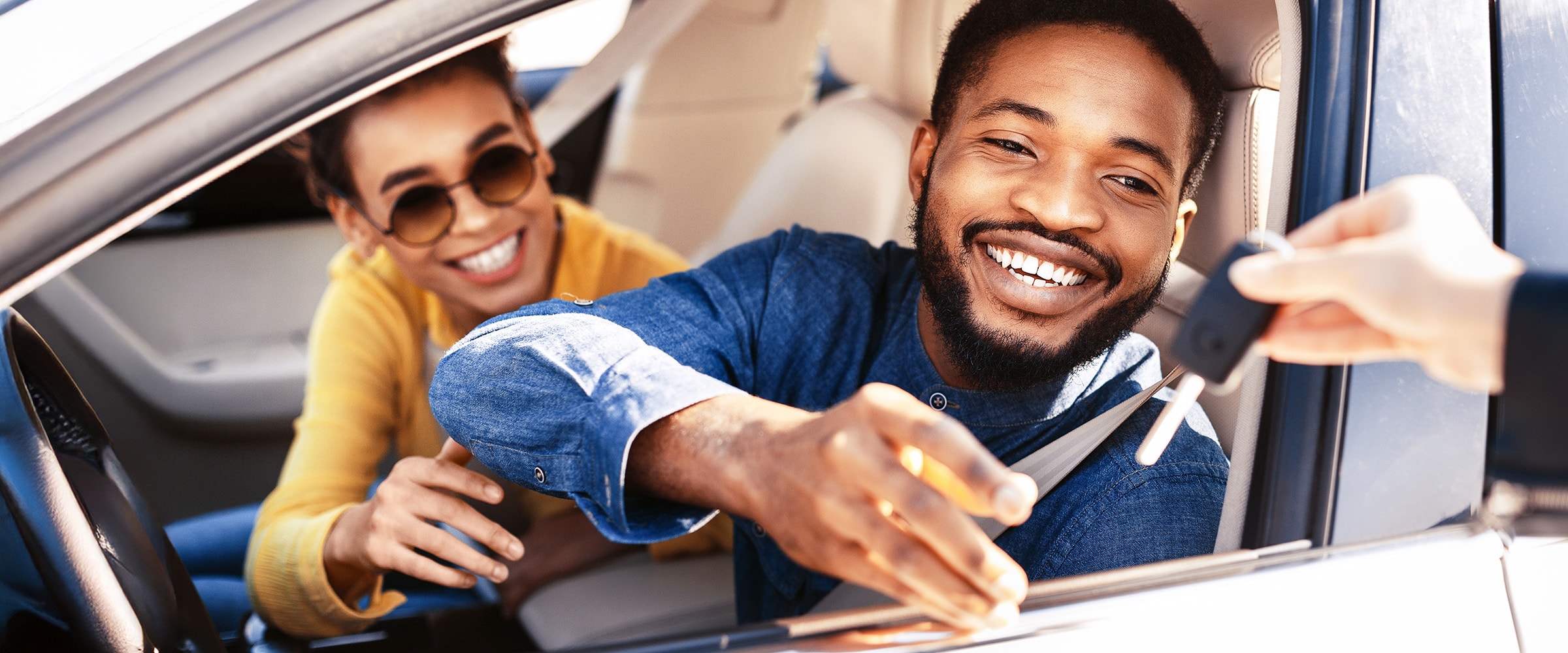 Photo of man in new car being handed the keys.