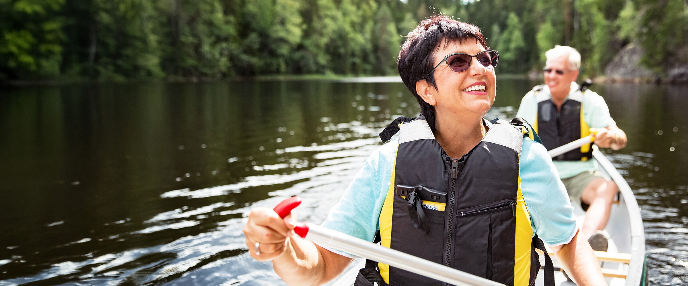 Photo of couple kayaking in separate kayaks.