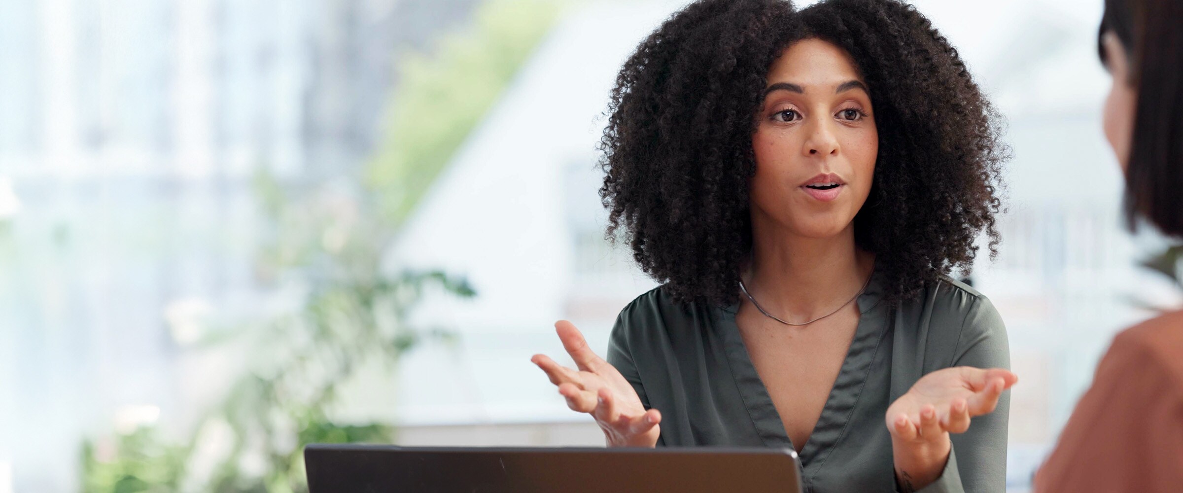 Photo of African American woman talking to another woman.