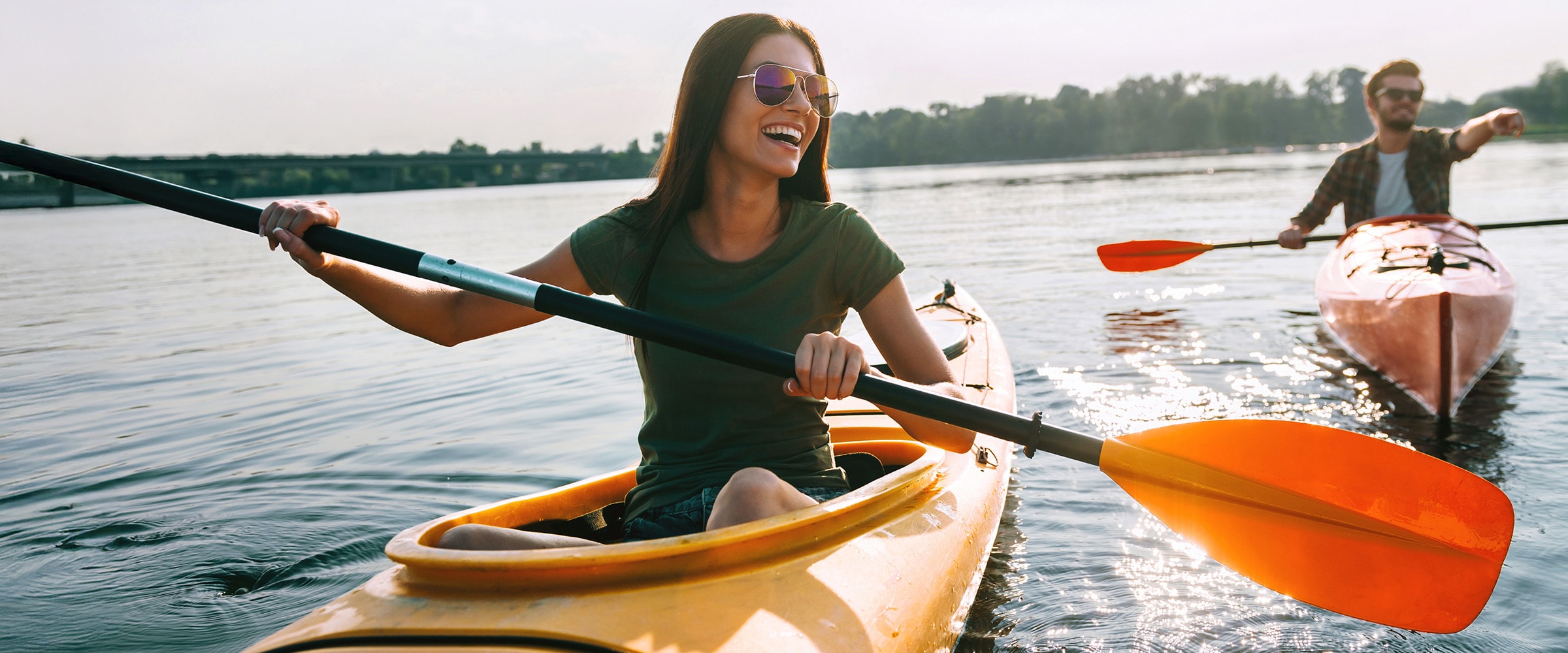 Photo of two people in two kayaks rowing in tandem.