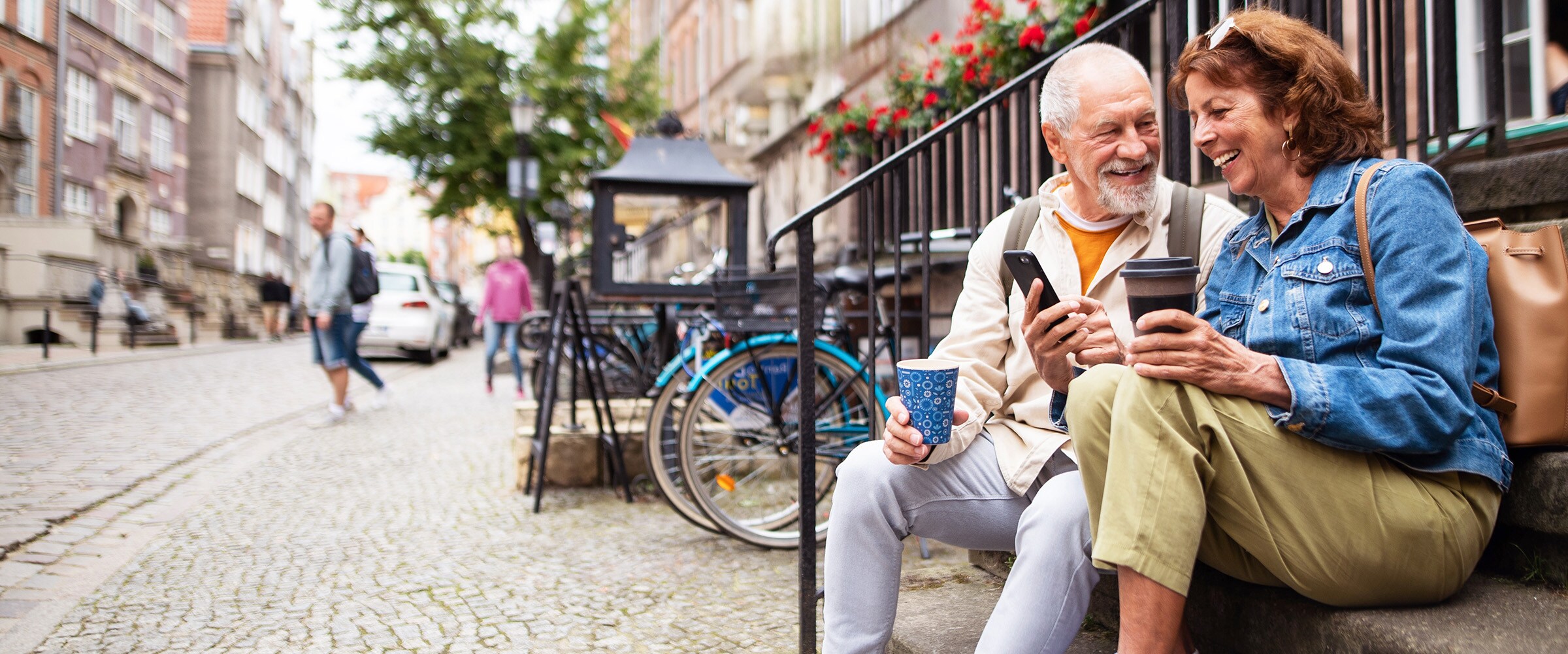 Photo of couple sitting on iron cast stairs in what looks to be a city overseas.