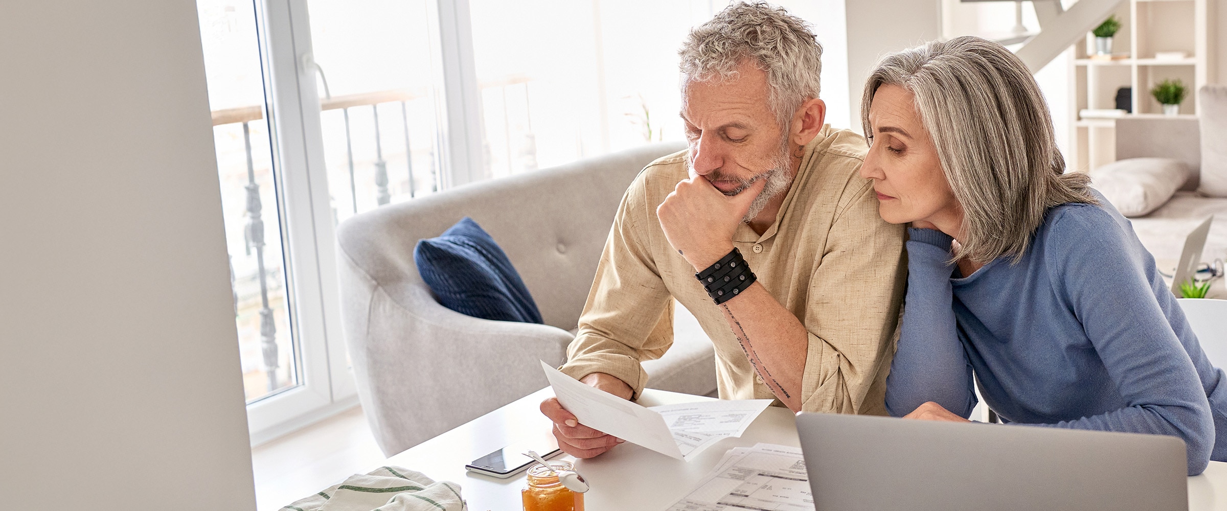 Photo of couple at table looking over their finances.