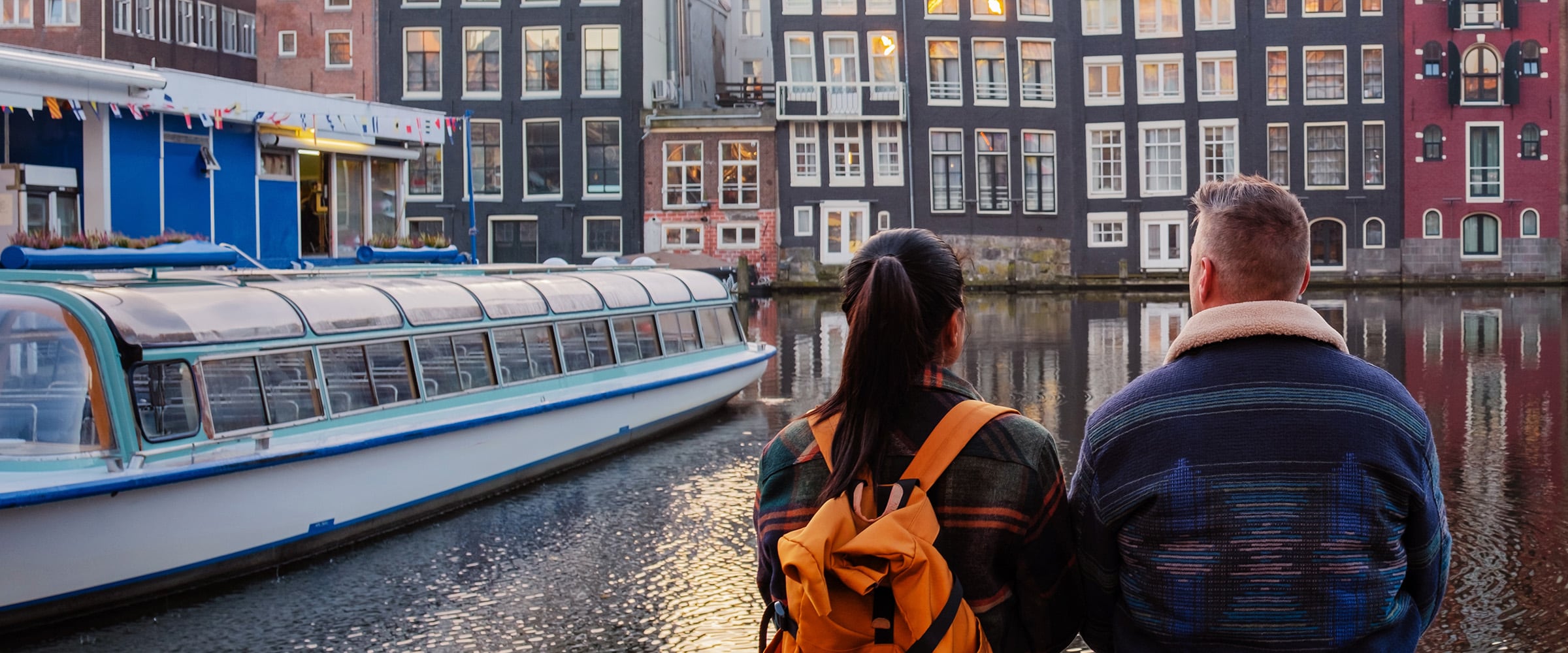Photo of couple on a dock watching boats on vacation.