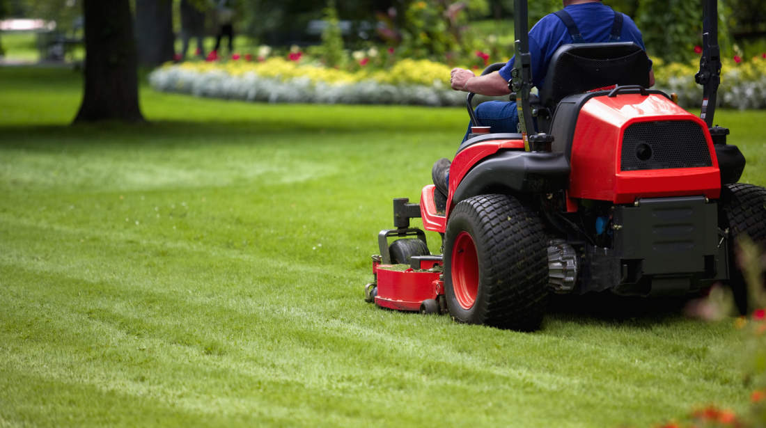 Man mowing large nicely landscaped yard.