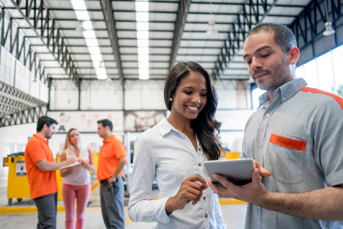 Auto service professional reviewing Car Care financing transaction with woman.